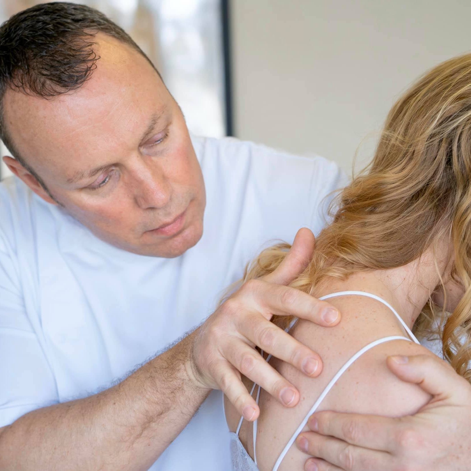 Robert Cartwright performing chiropractic treatment on woman's upper back