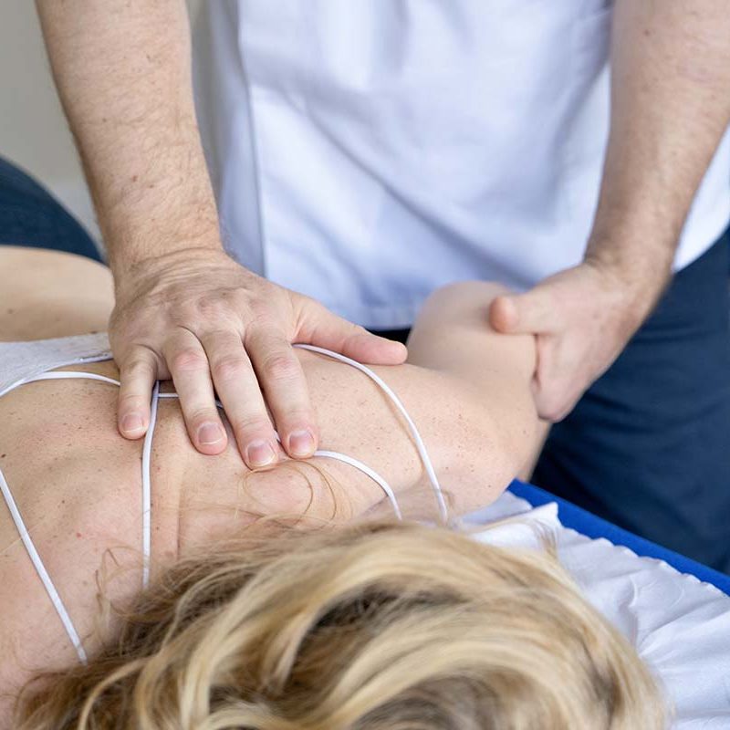 Robert Cartwright performing chiropractic treatment on woman's upper back